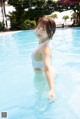 A woman in a white bathing suit standing in a pool.