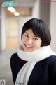 A woman wearing a white scarf smiles at the camera.