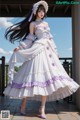 A woman in a white and purple dress is posing for a picture.