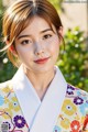 A woman in a colorful kimono poses for a picture.